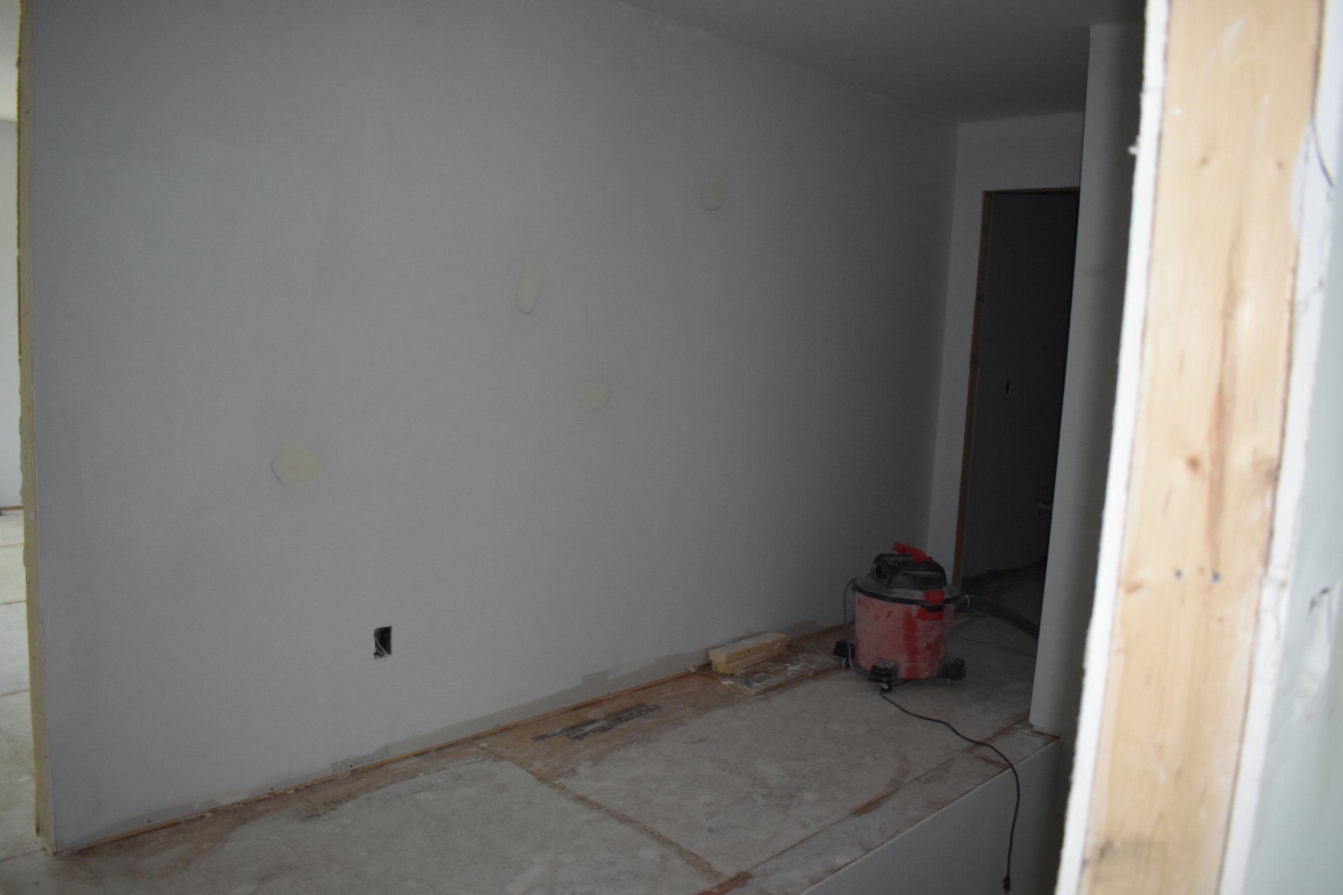 A vacuum cleaner is sitting on the floor in a room under construction.
