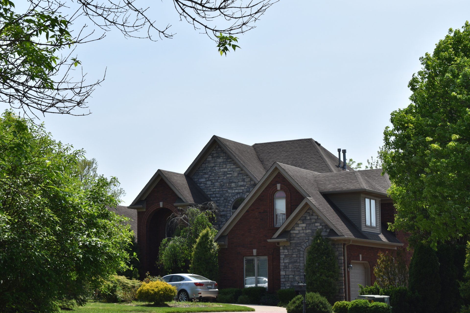 A large brick house with a car parked in front of it