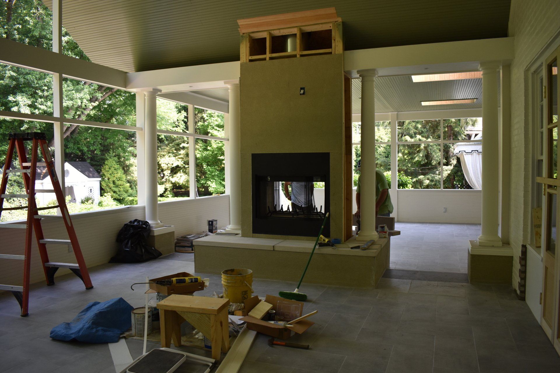 A room with a fireplace and a ladder in it