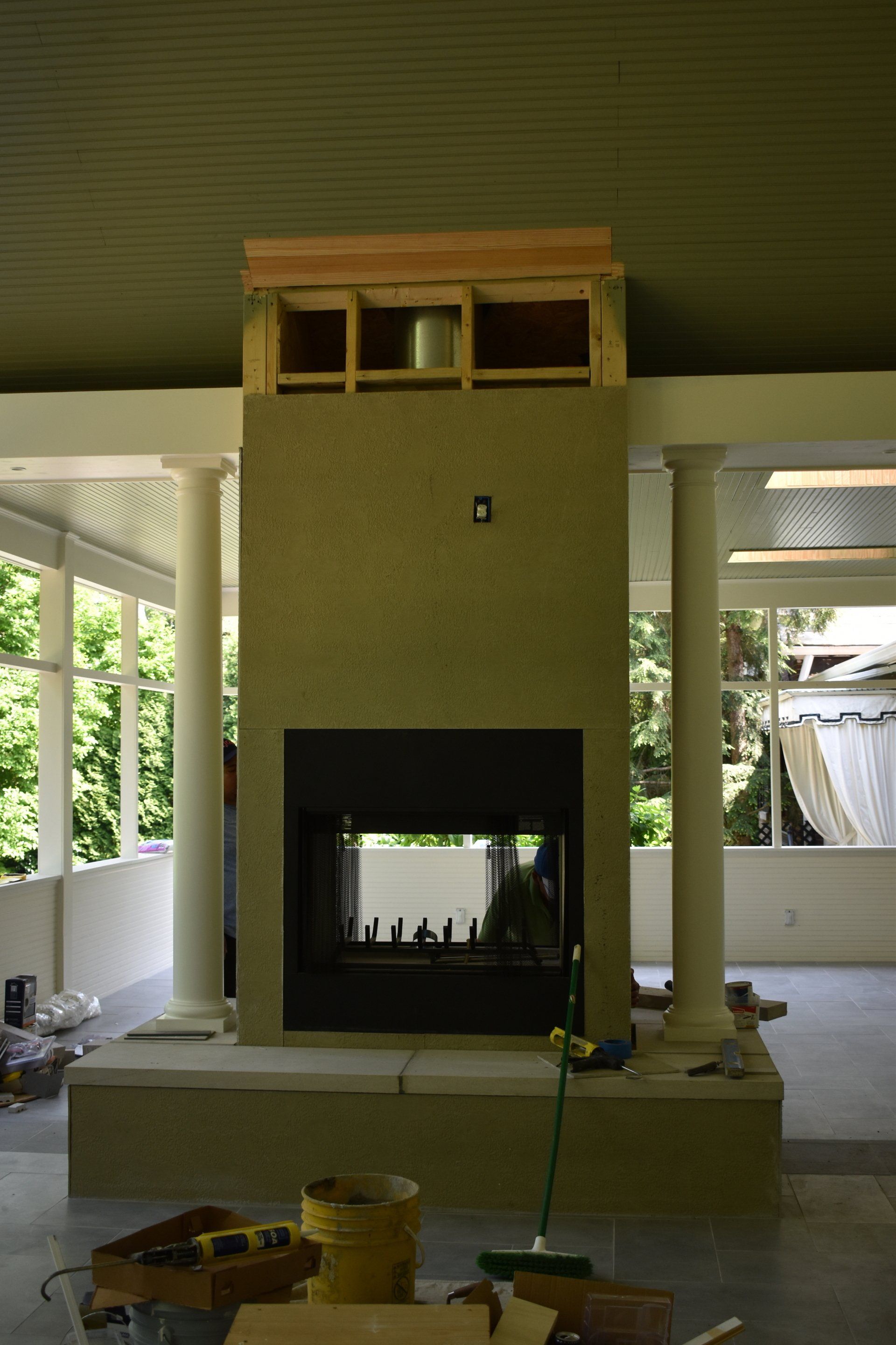 A fireplace is being built in a room with columns