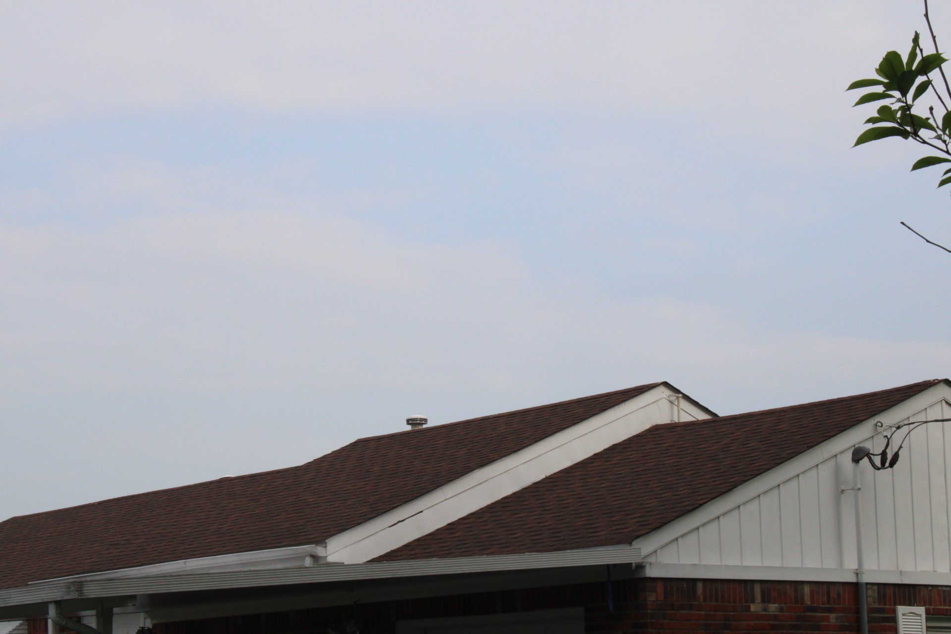 A brick house with a brown roof and white trim