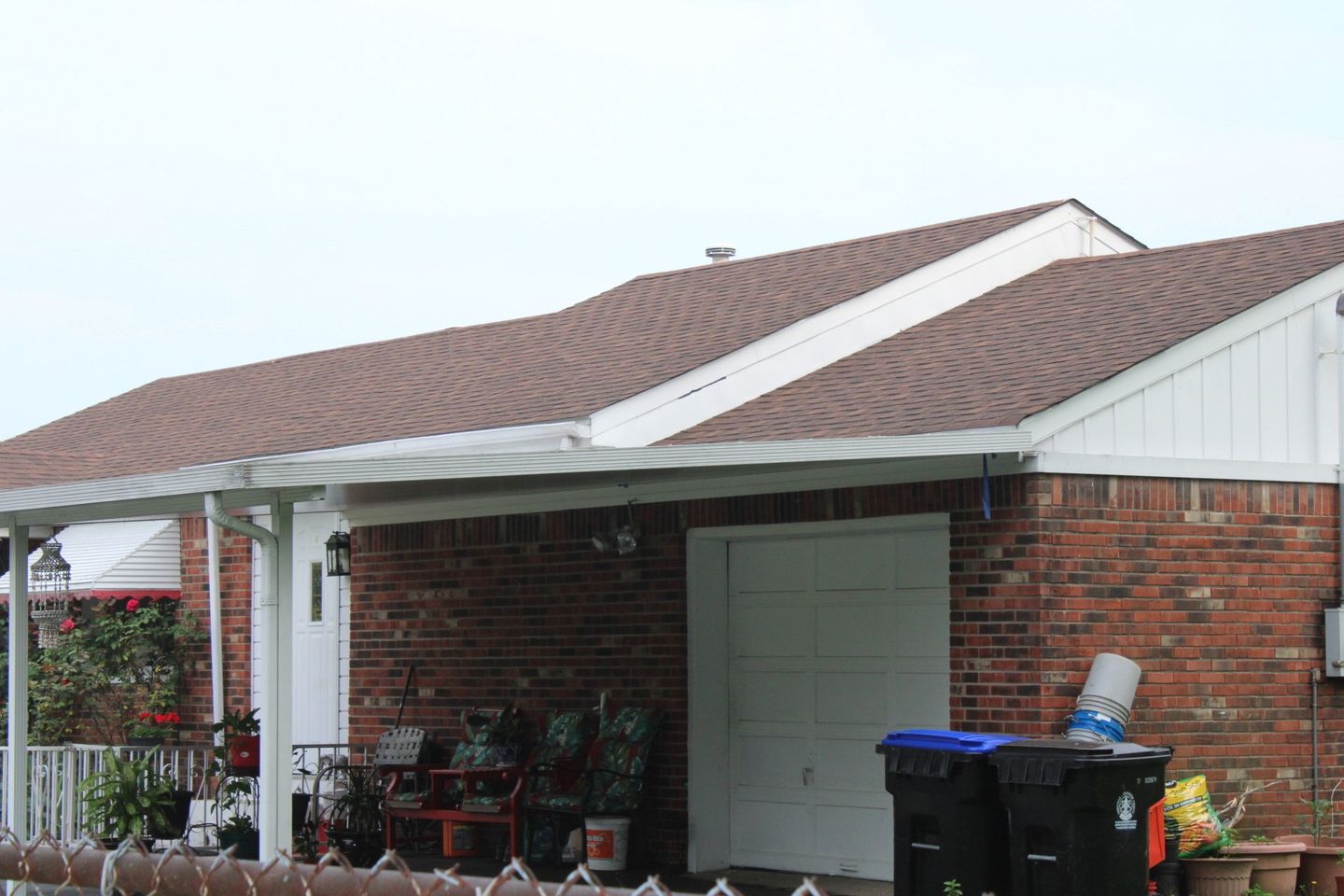 A brick house with a brown roof and a white trim