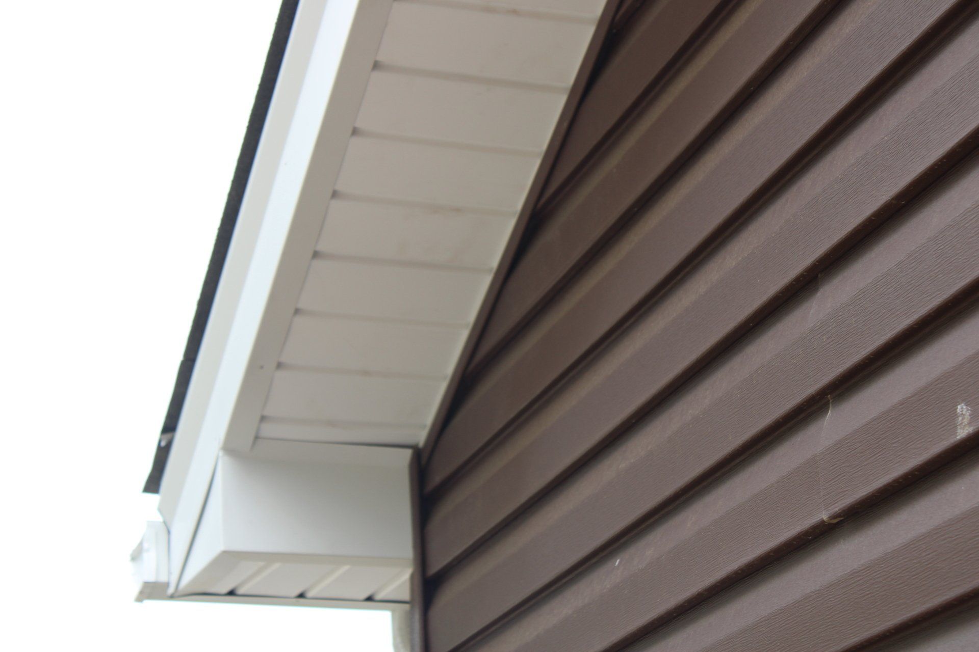 A brown and white house with a white roof