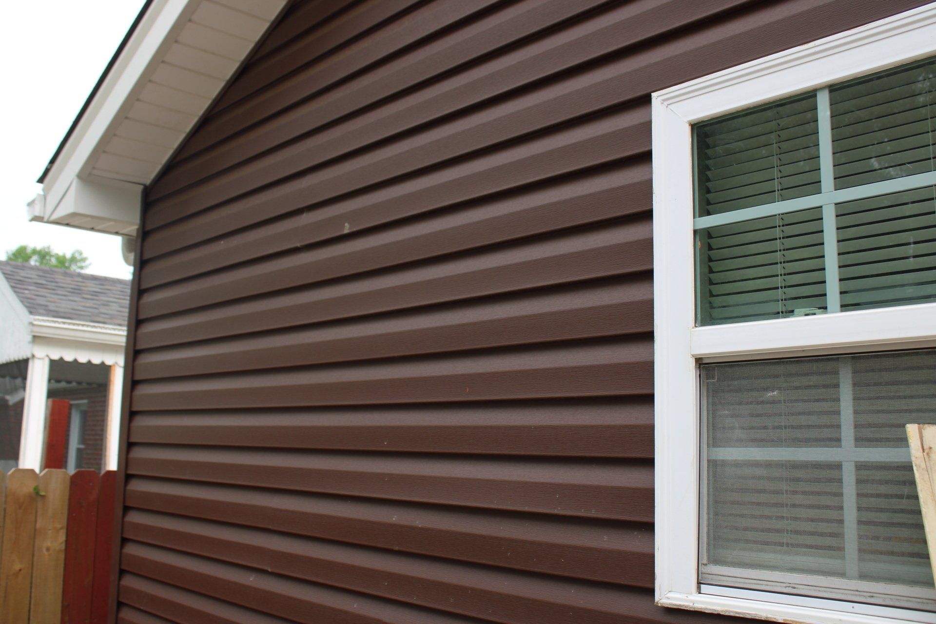 A brown house with a white window on the side