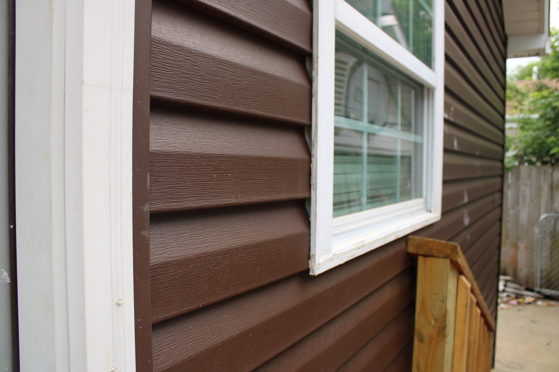 A house with brown siding and a white window