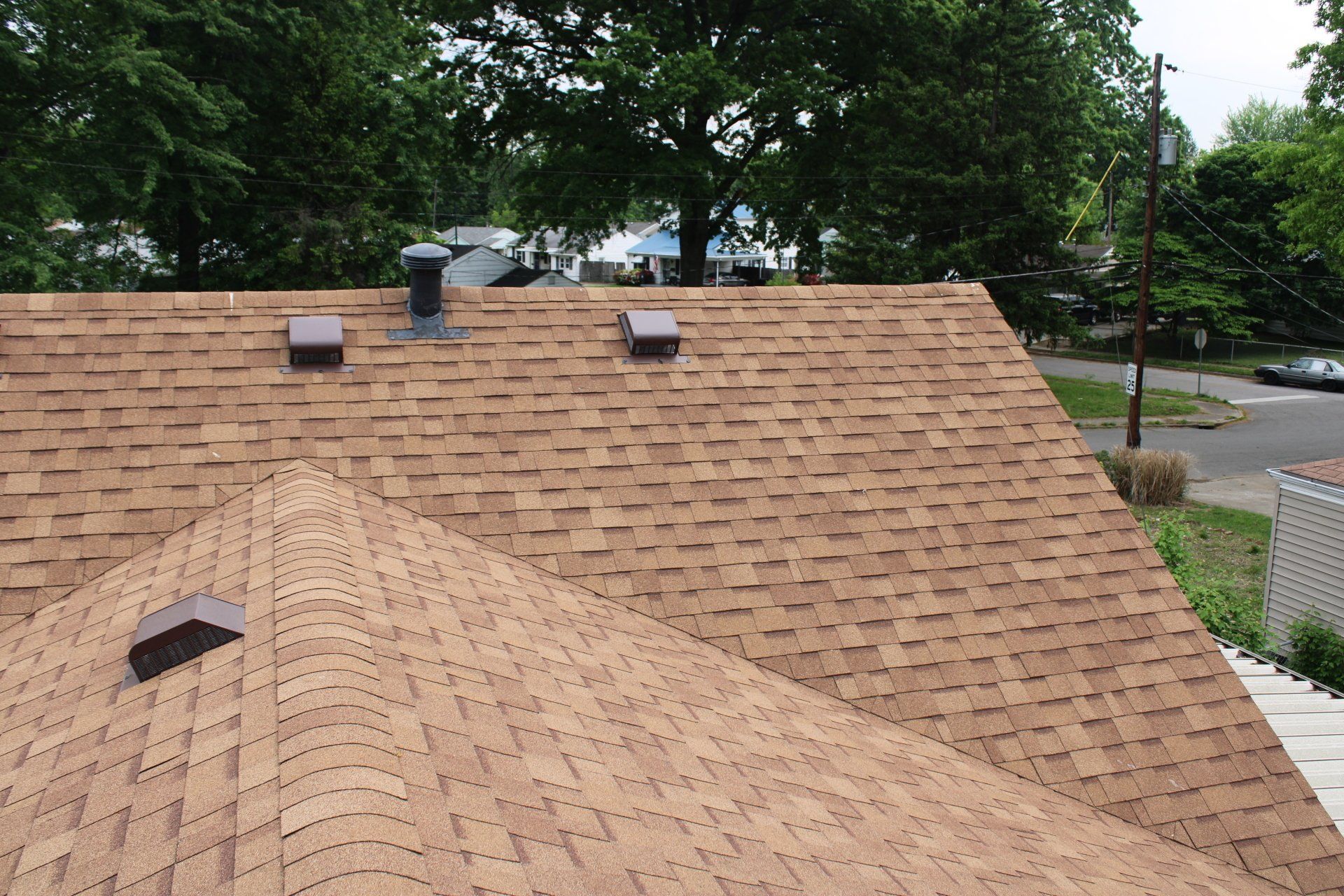 The roof of a house with a brown shingle roof
