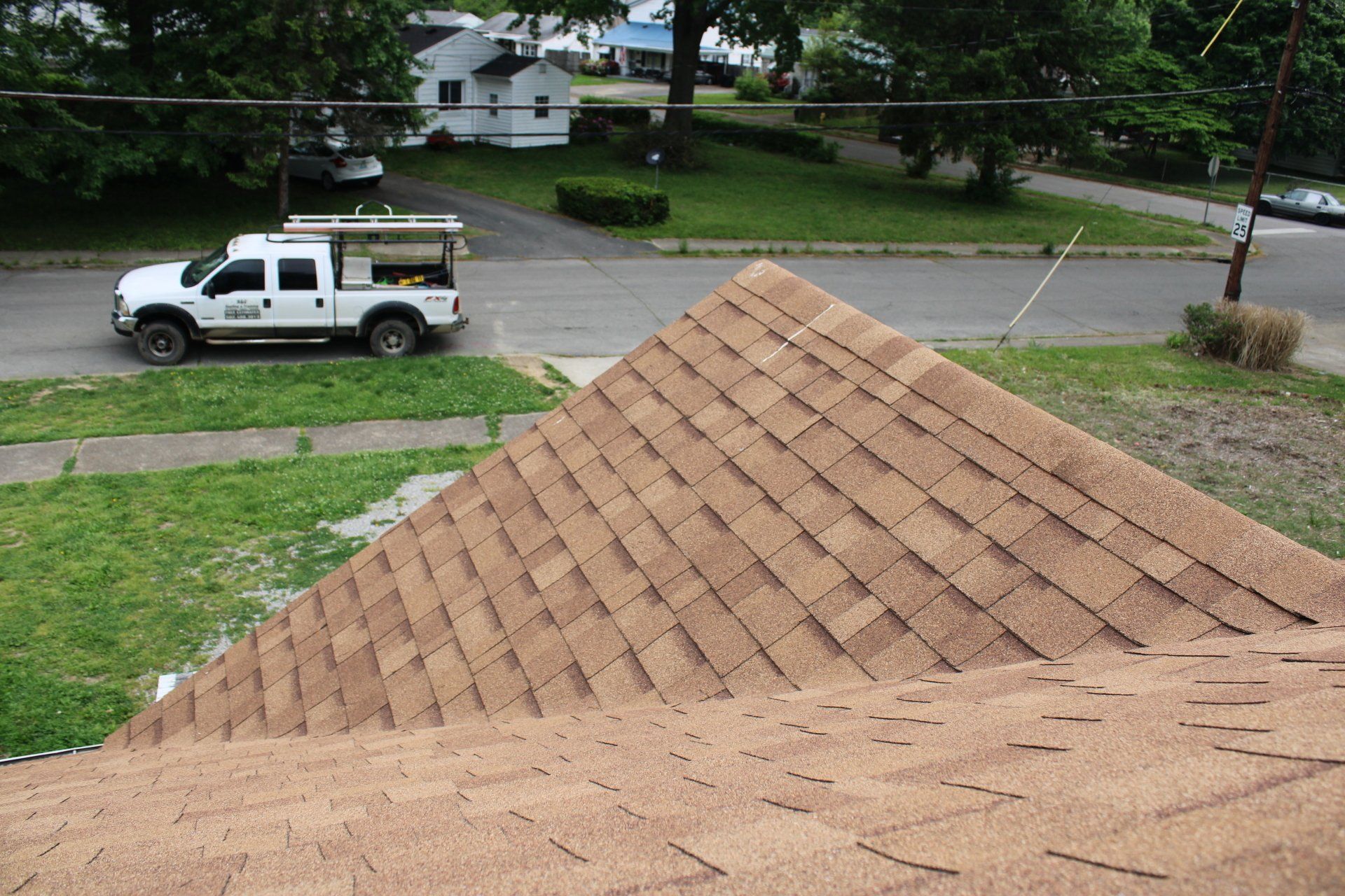 A white truck is parked on the side of the road next to a roof