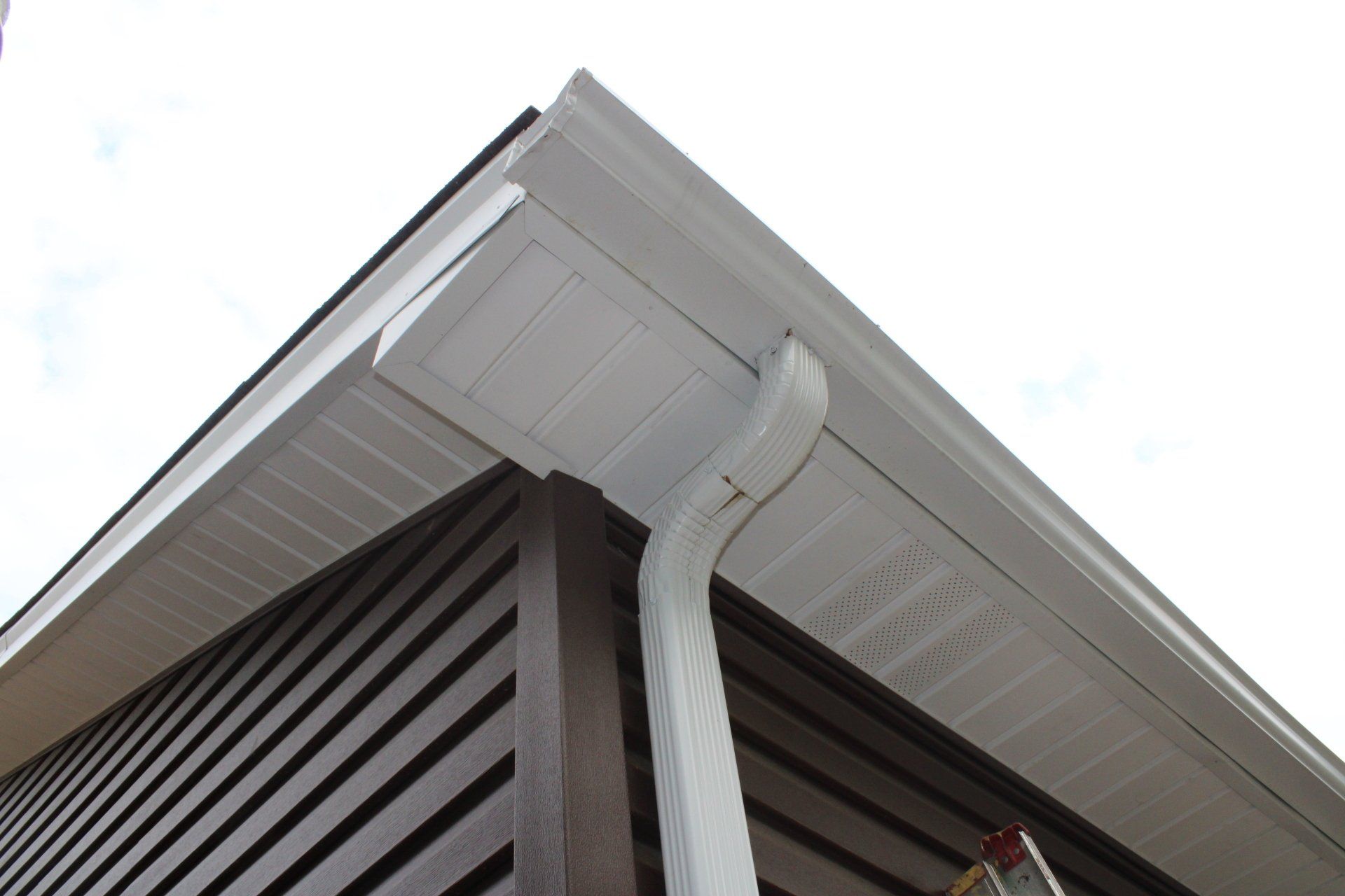 A white gutter on the side of a house