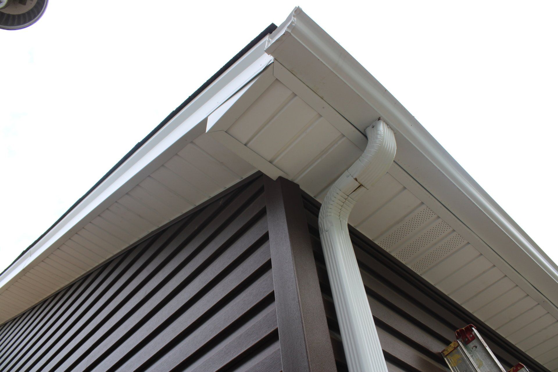 A white gutter on the side of a house