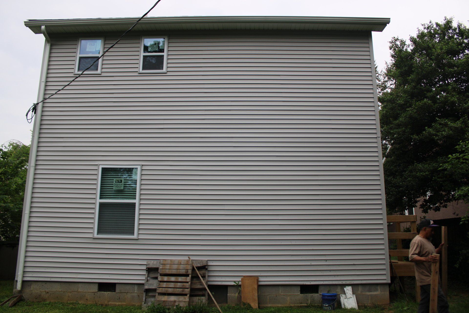 A man is standing in front of a large white house.