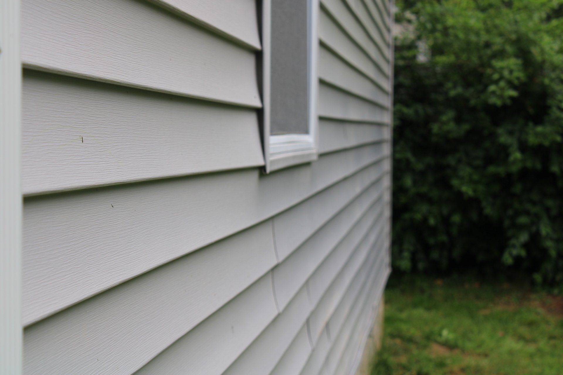 A white house with a window on the side of it.