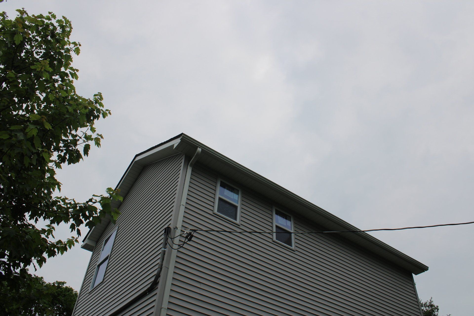 Looking up at a house with a cloudy sky in the background