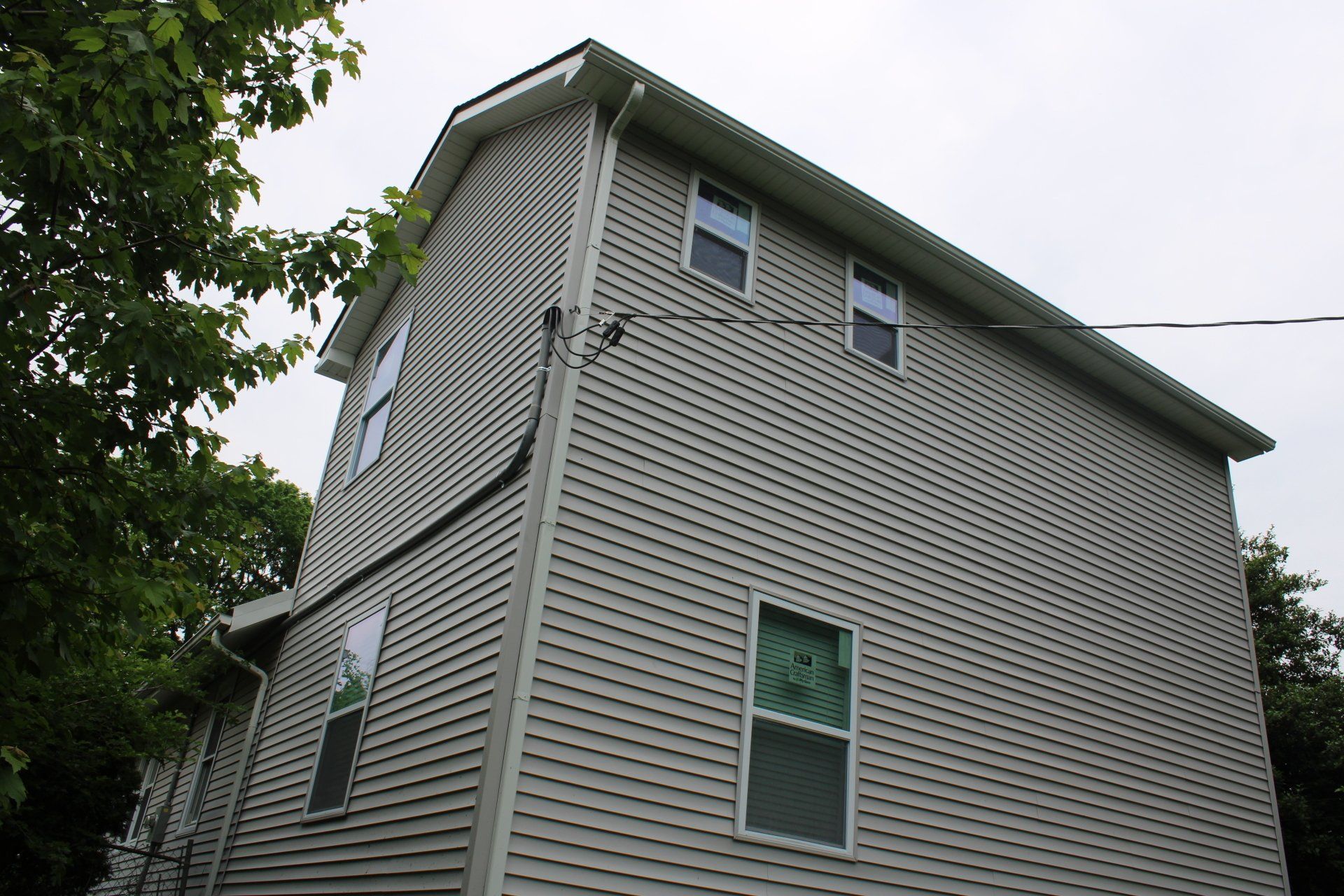 A house with a lot of windows is surrounded by trees