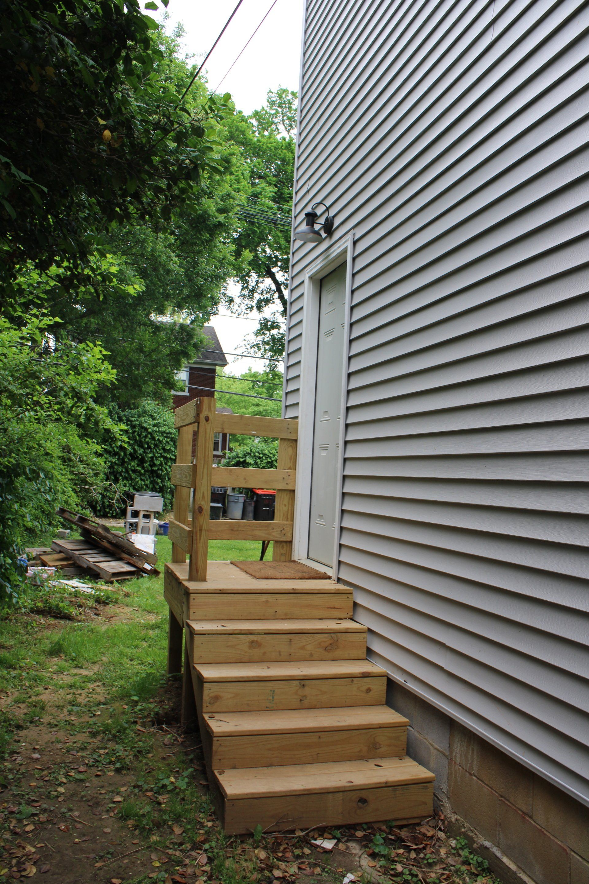 A house with a wooden deck and stairs leading to it.