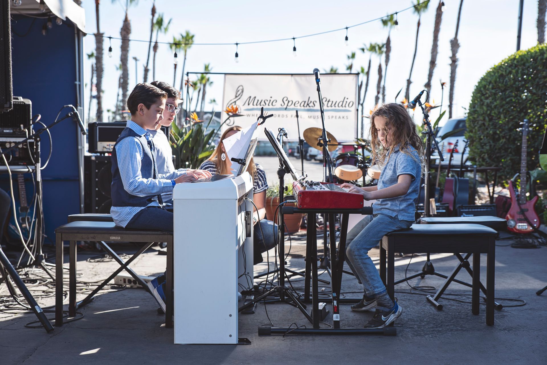 A group of young people are playing instruments on a stage.