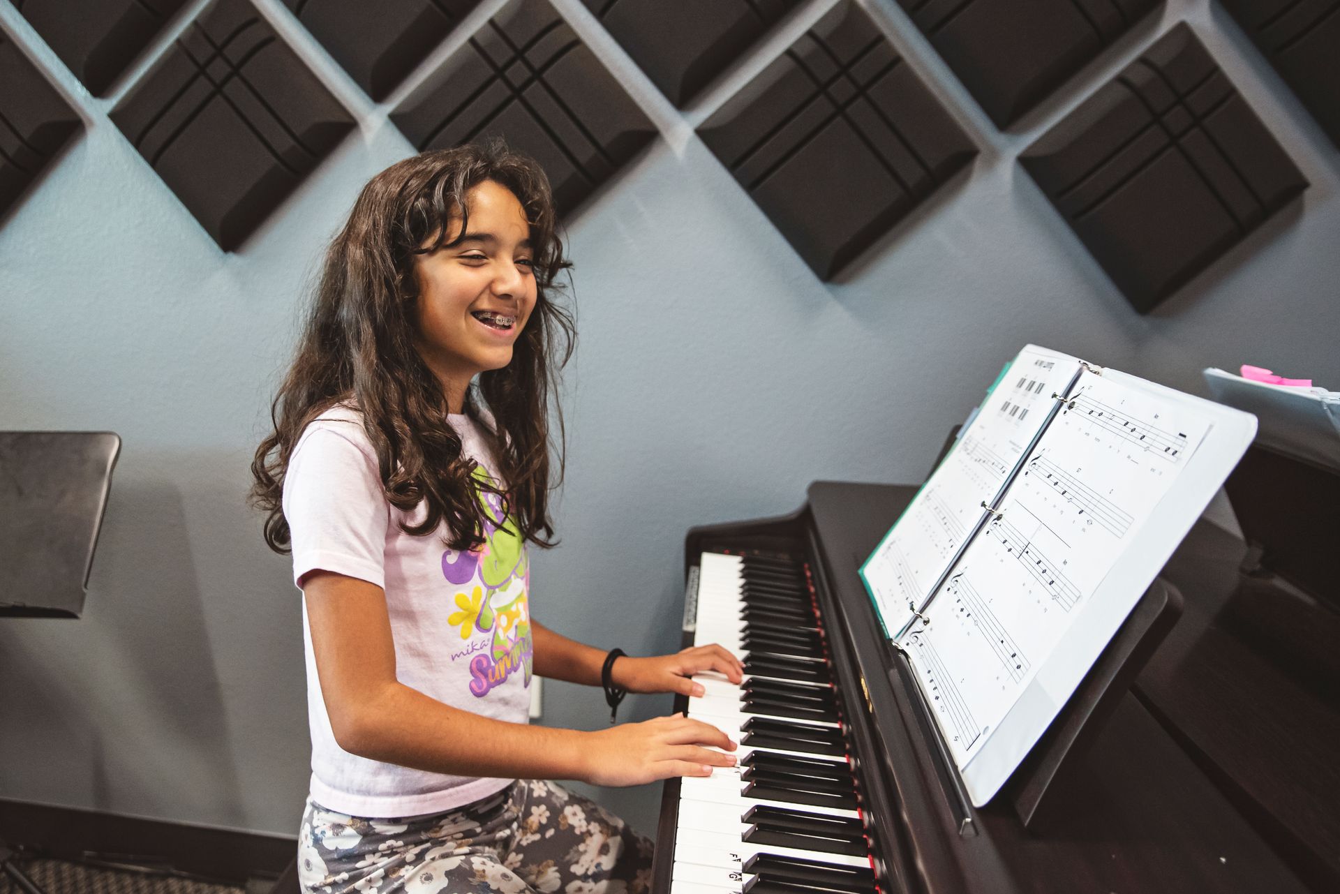 A person is playing a piano with their hands on the keys.