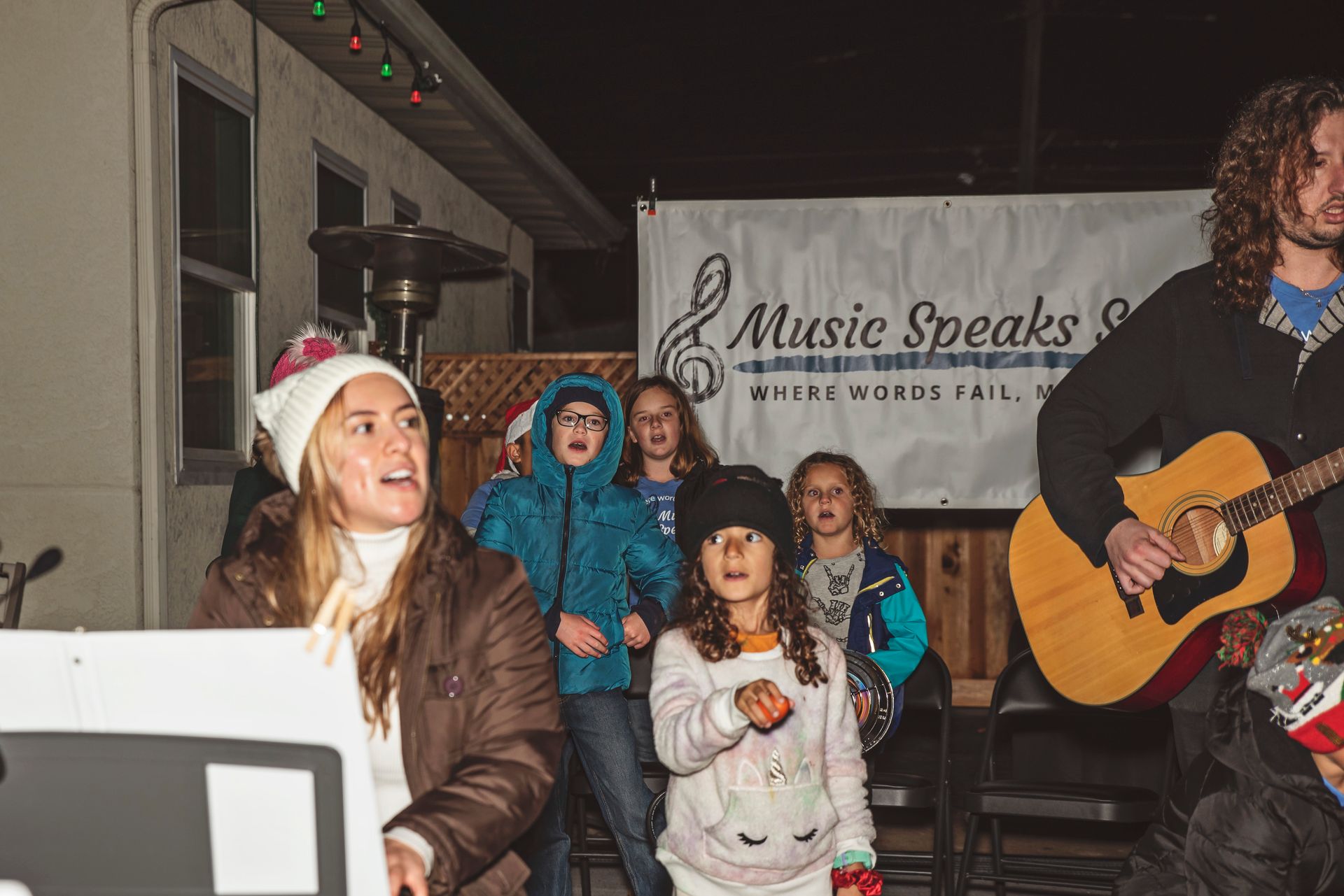 A group of people are playing instruments on a stage in front of a crowd.
