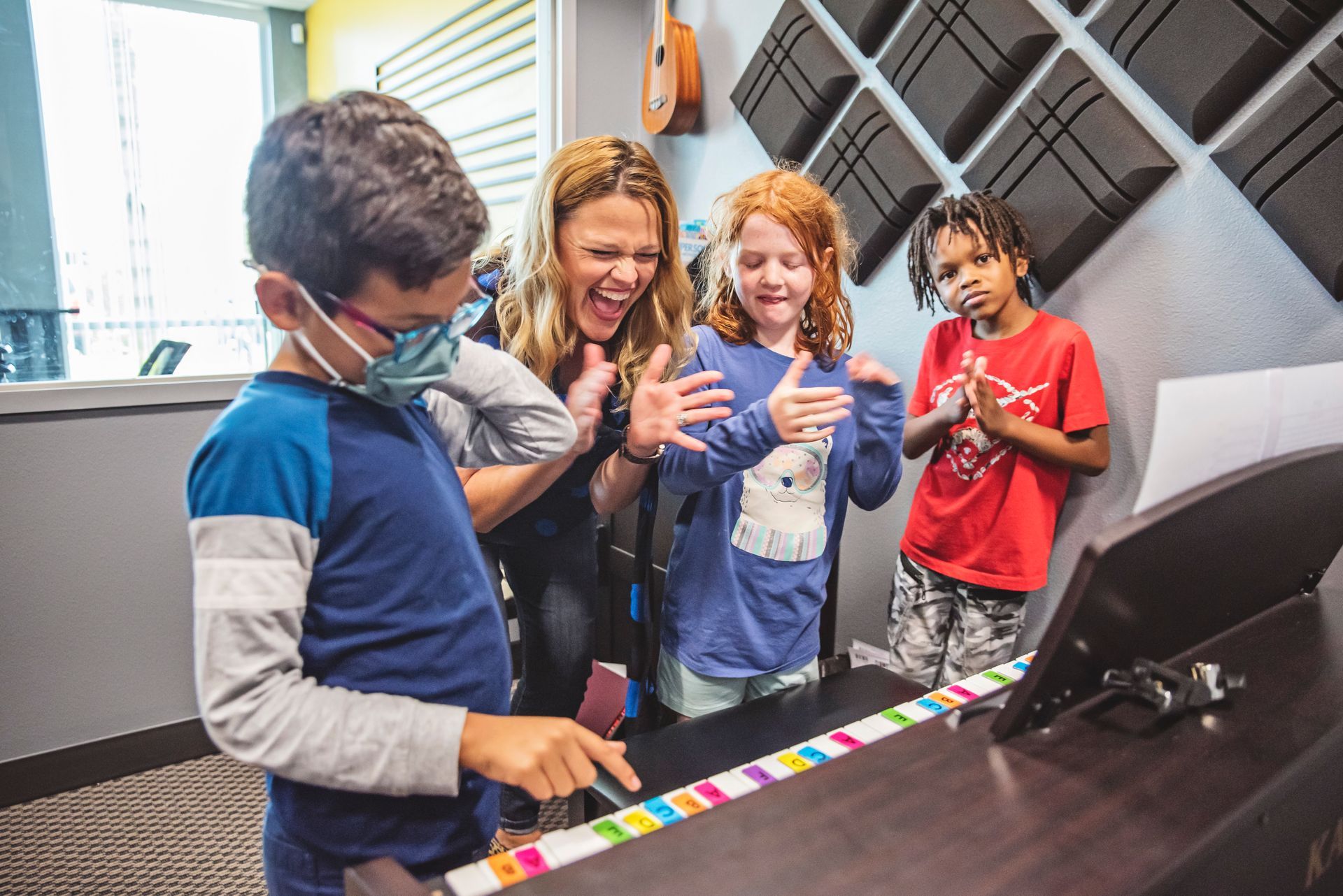 A group of children are playing a piano together.