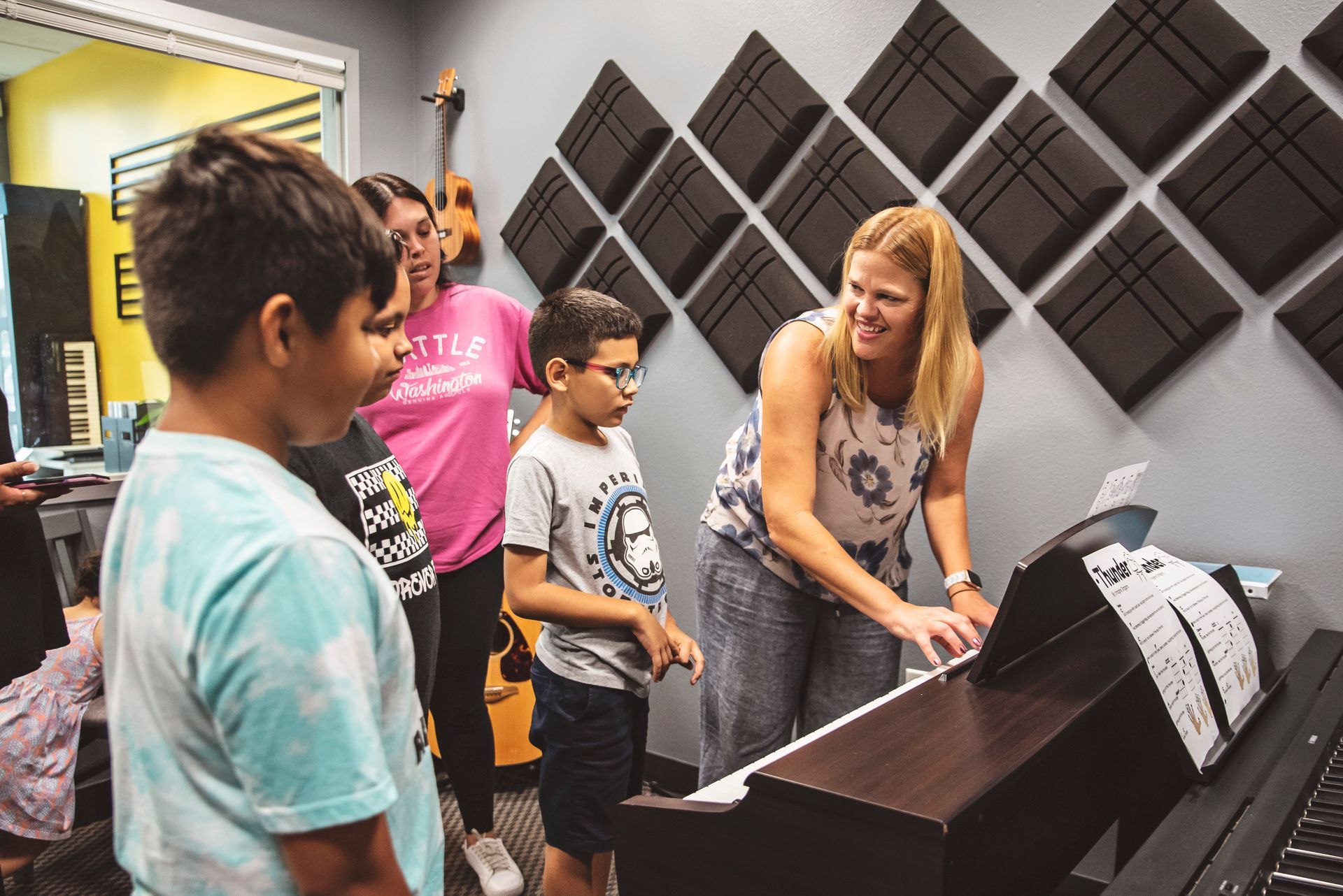 A young boy is holding a guitar and smiling.