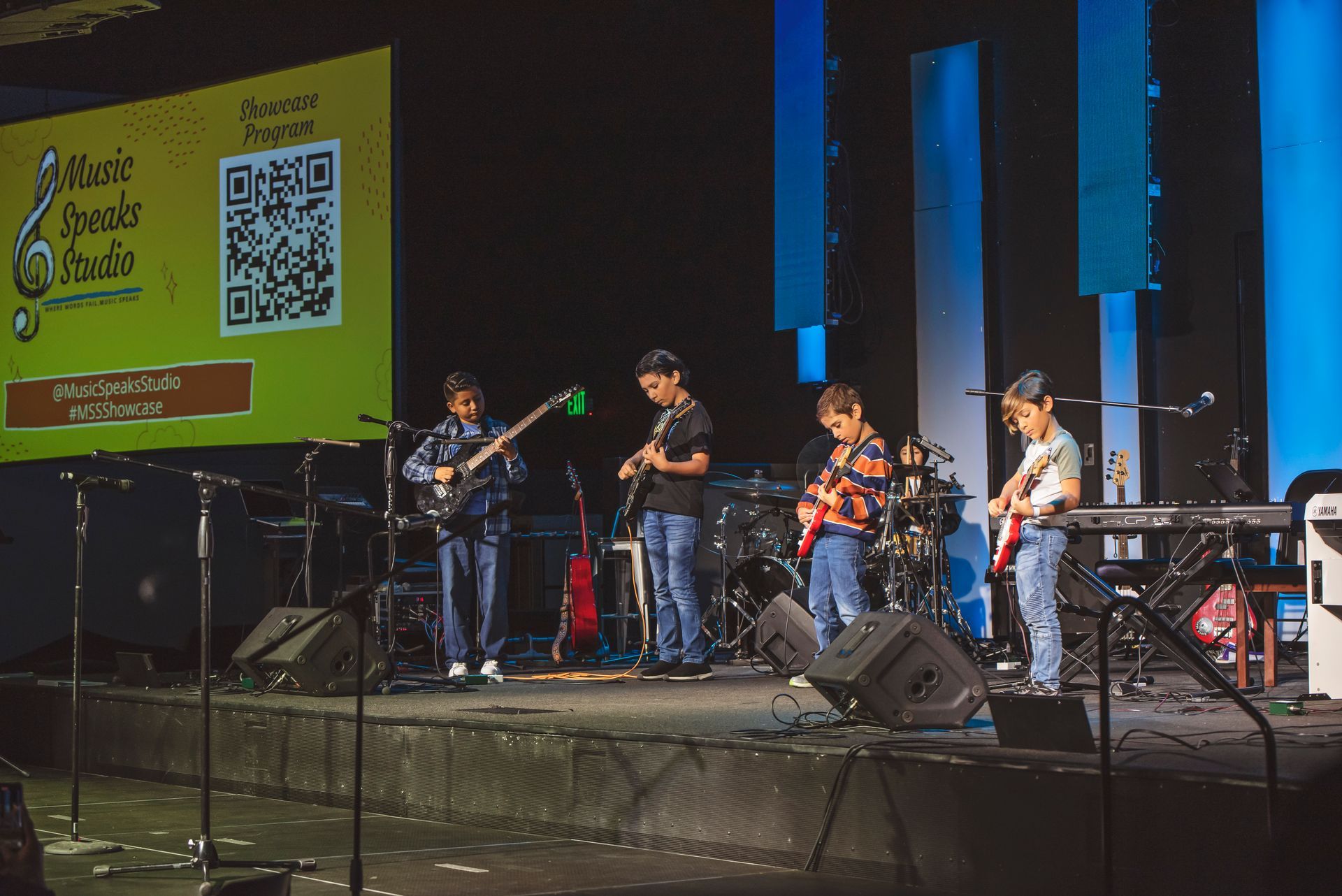 A group of people are playing instruments on a stage in front of a crowd.