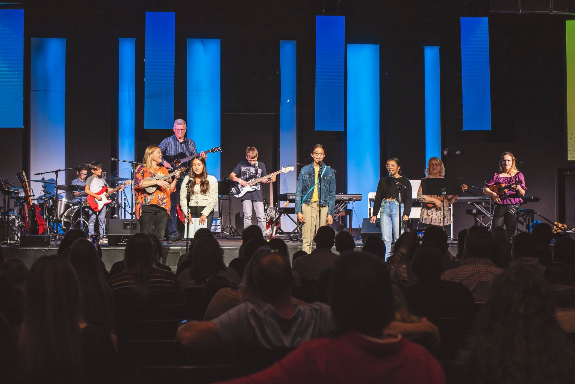 A group of people are standing on a stage in front of a crowd.