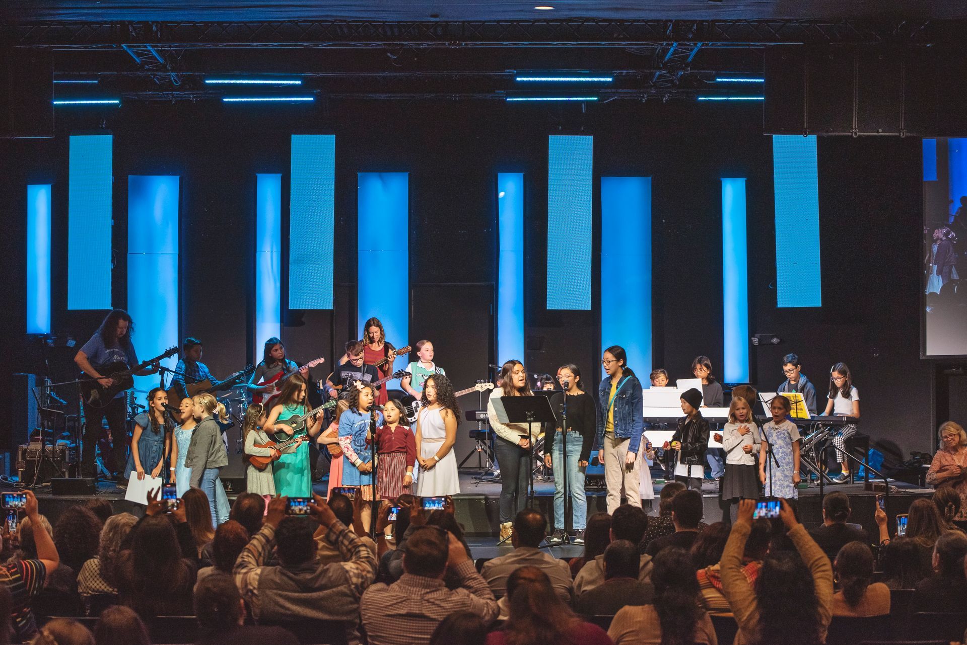 A group of people are standing on a stage in front of a crowd.