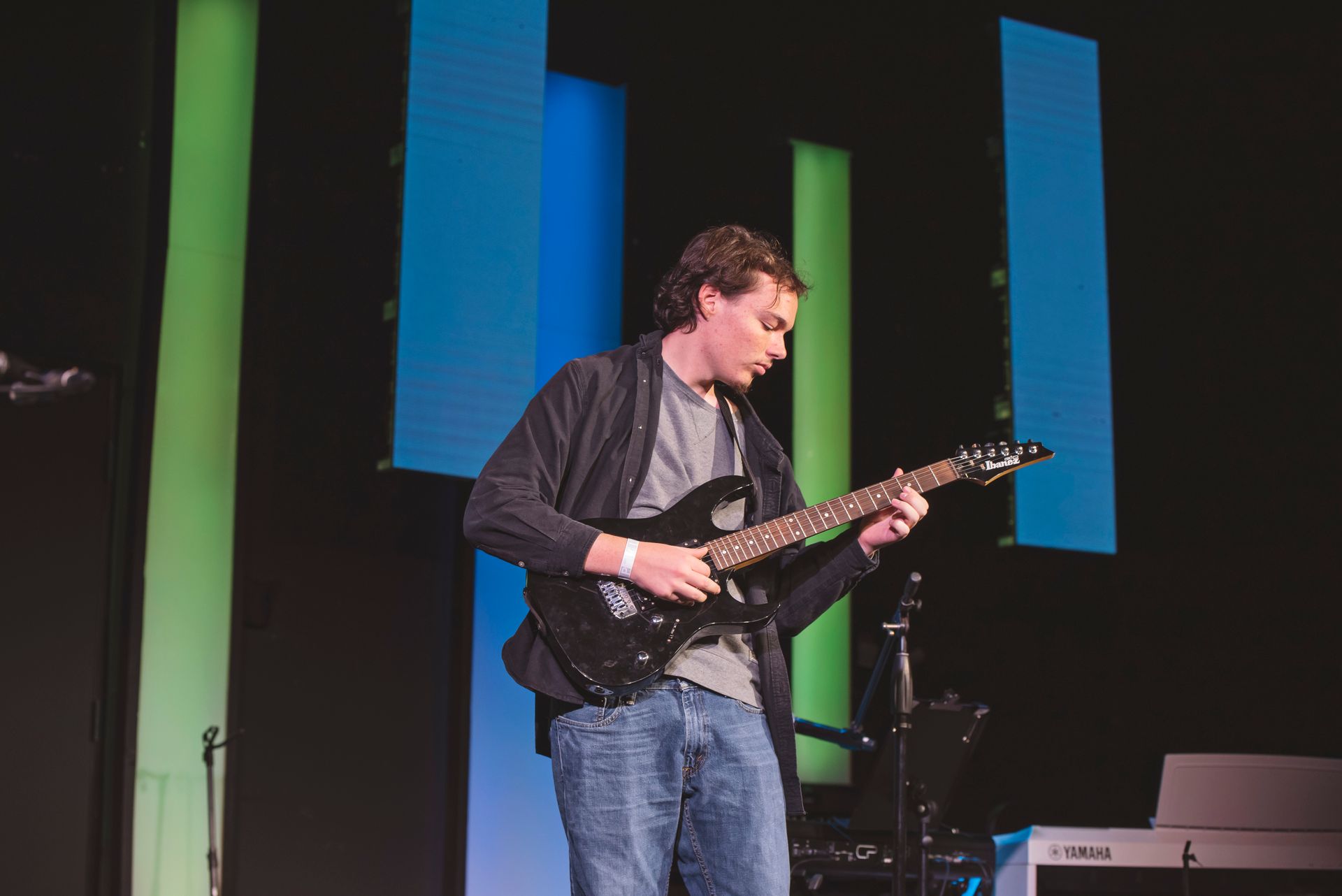 A man is playing a guitar on a stage.