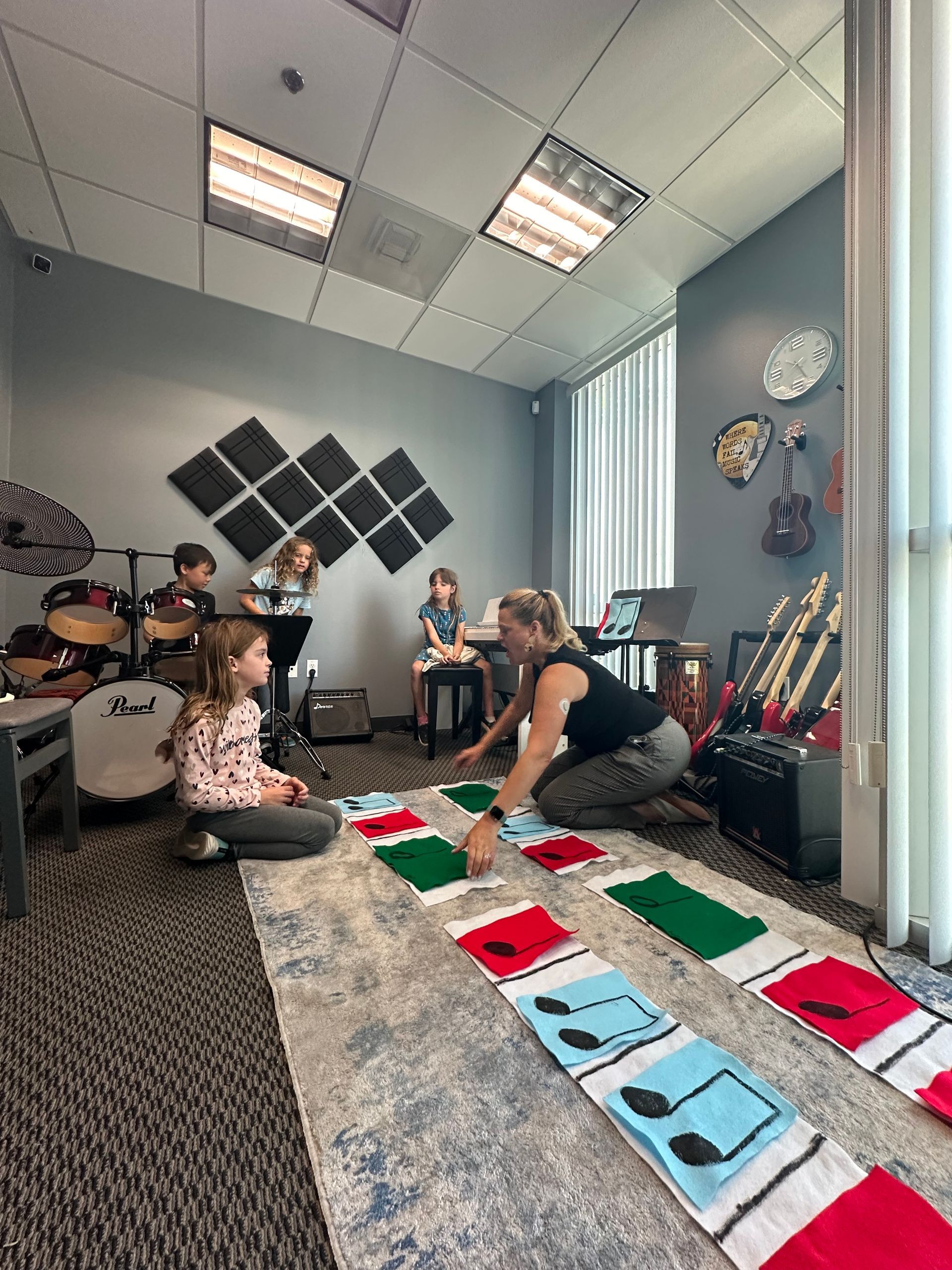 A group of children are playing a game in a music room.