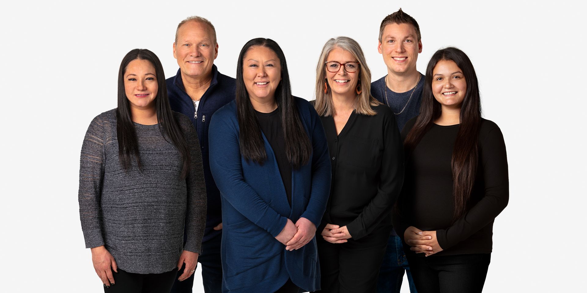Group photo of diverse people, standing close together, smiling, against a white background.