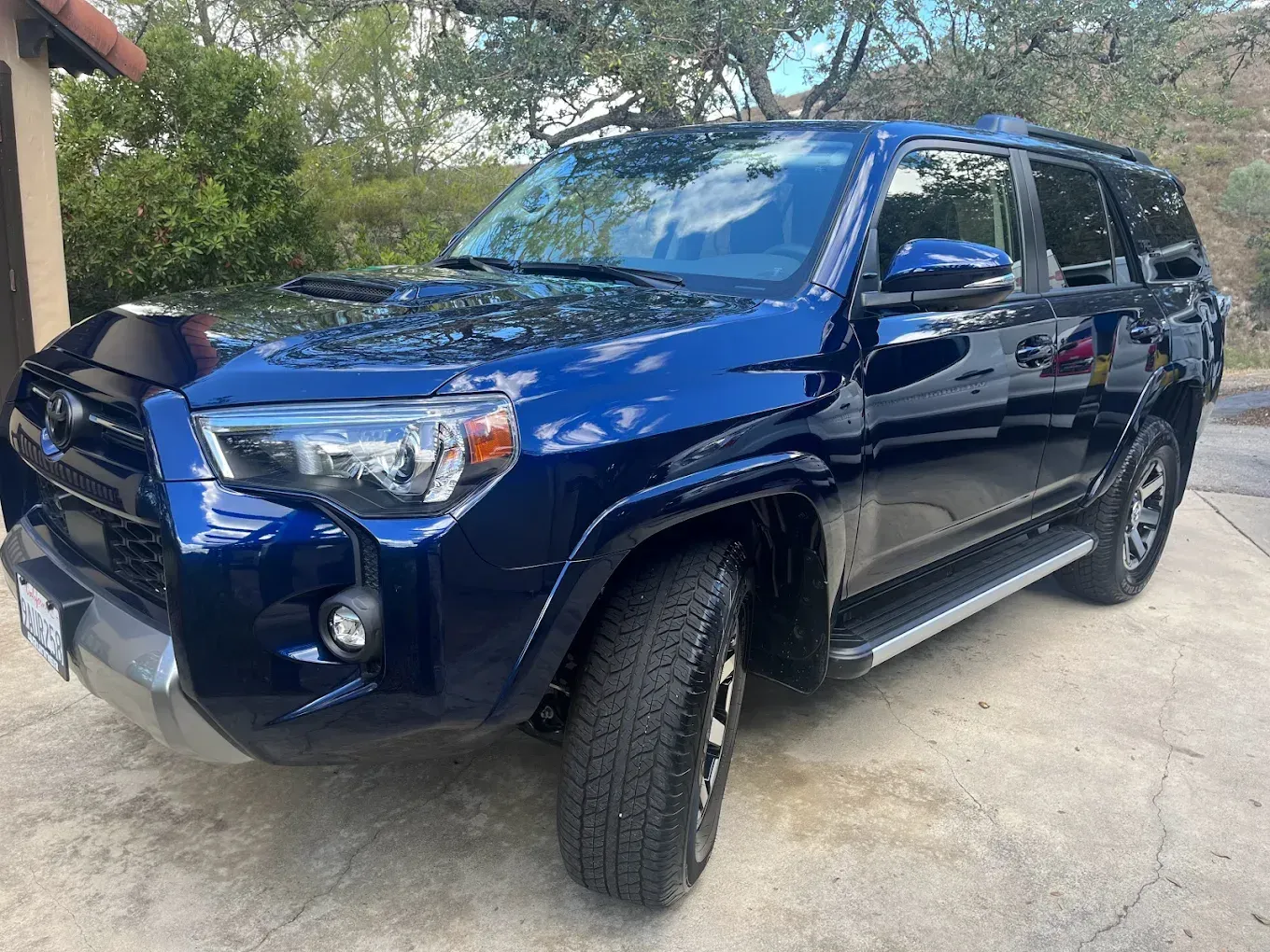 Blue Toyota 4Runner SUV parked outdoors, reflecting sunlight.