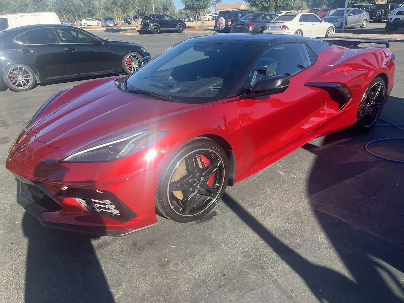 Red Chevrolet Corvette sports car parked on asphalt.