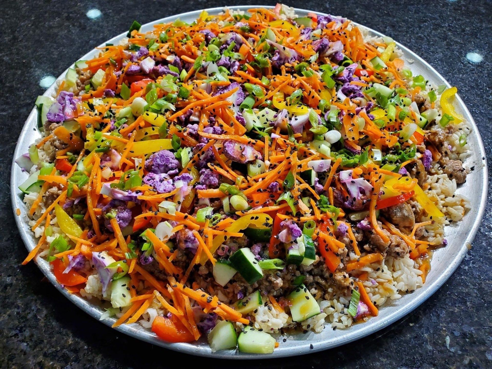 A white plate topped with rice and vegetables on a table