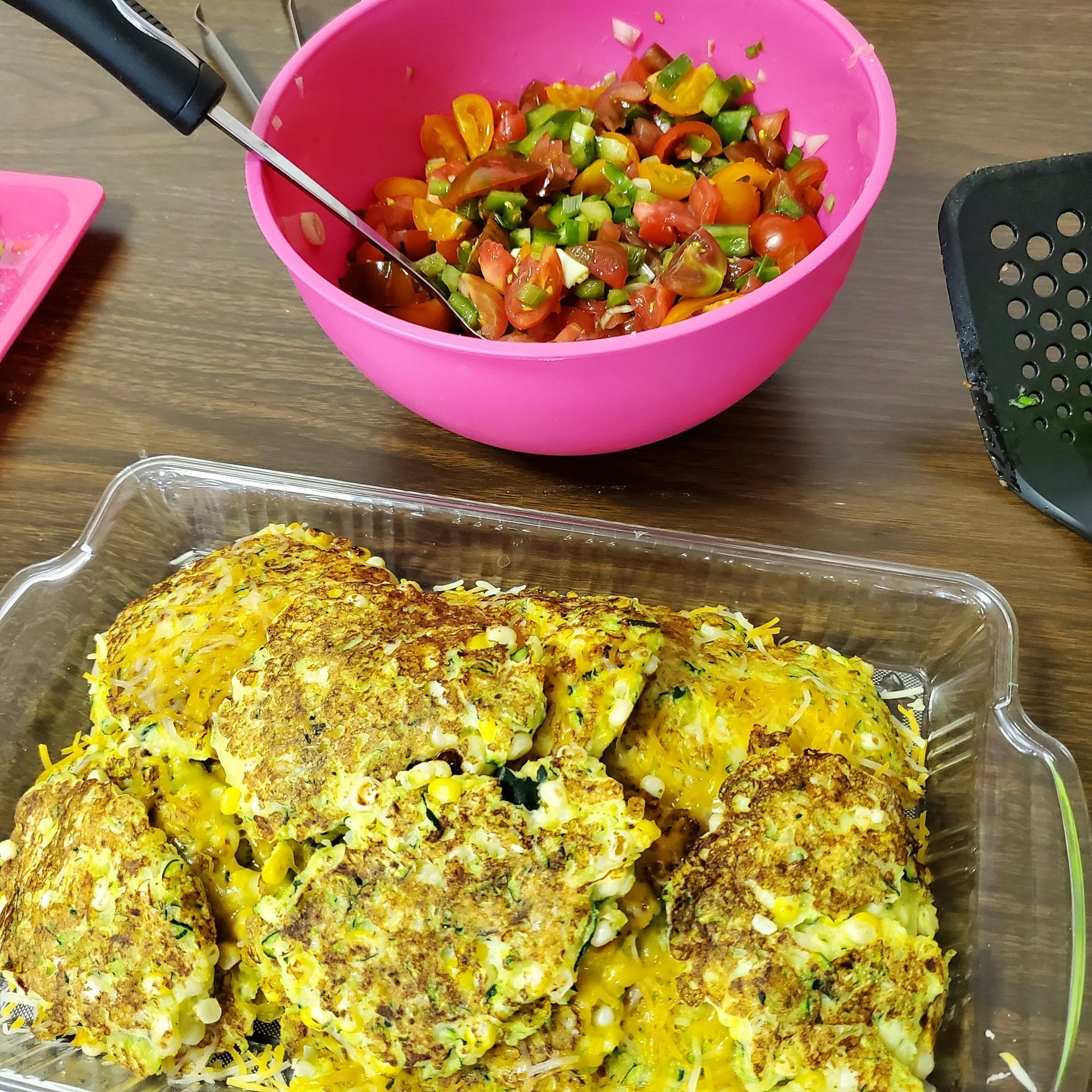 A plate of food next to a bowl of salsa on a table.