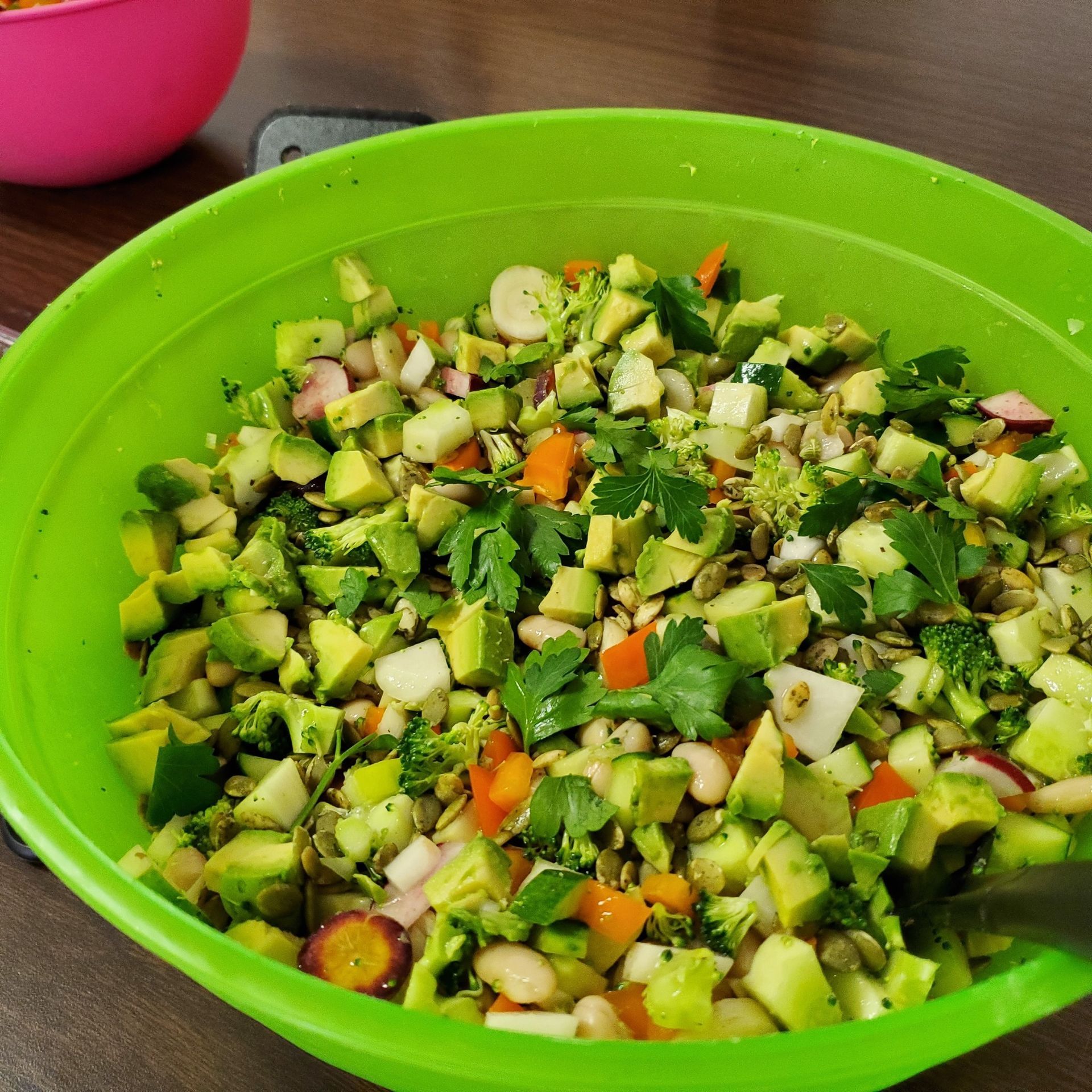 A green bowl filled with a variety of vegetables