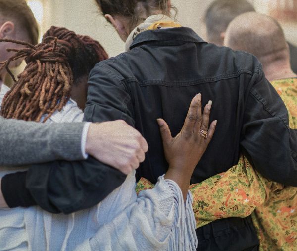 Young person looking up, outdoors. Soft sunlight, trees in background.