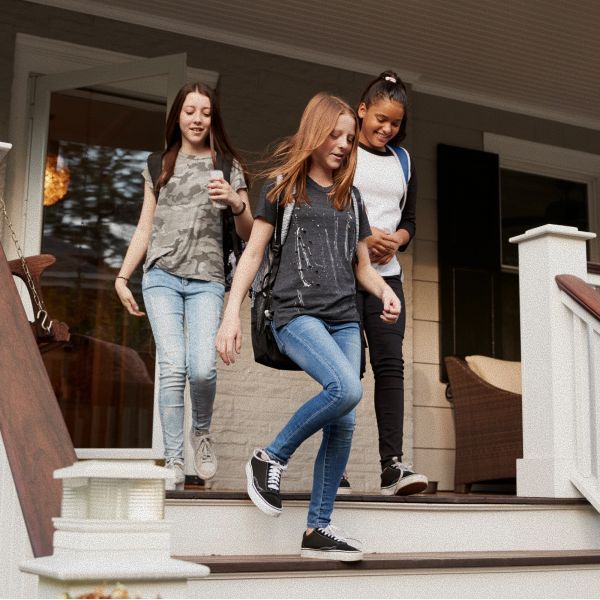 Young person looking up, outdoors. Soft sunlight, trees in background.