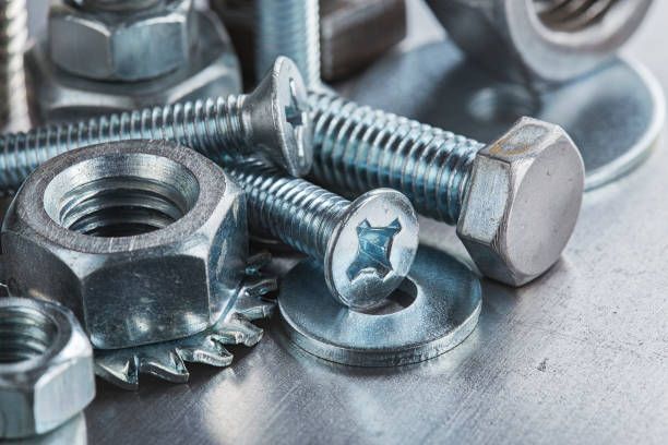 A close up of nuts and bolts on a metal surface.