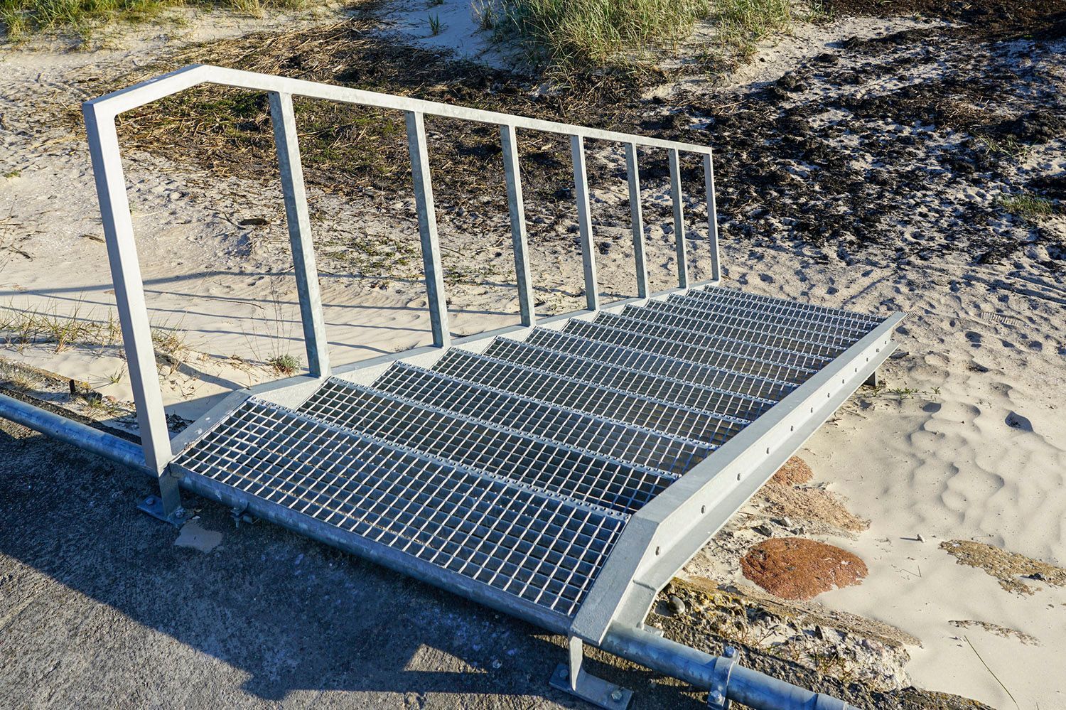 A metal staircase is sitting on the side of a road.