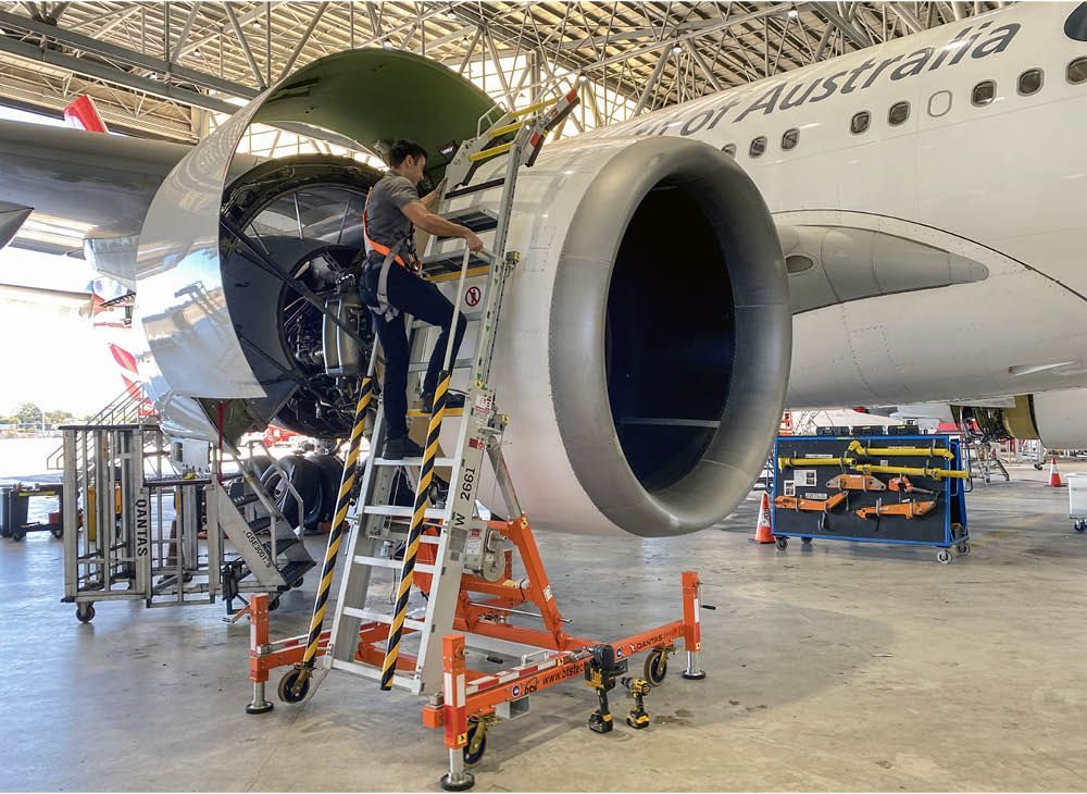 A construction worker is working on a pipe in a trench.