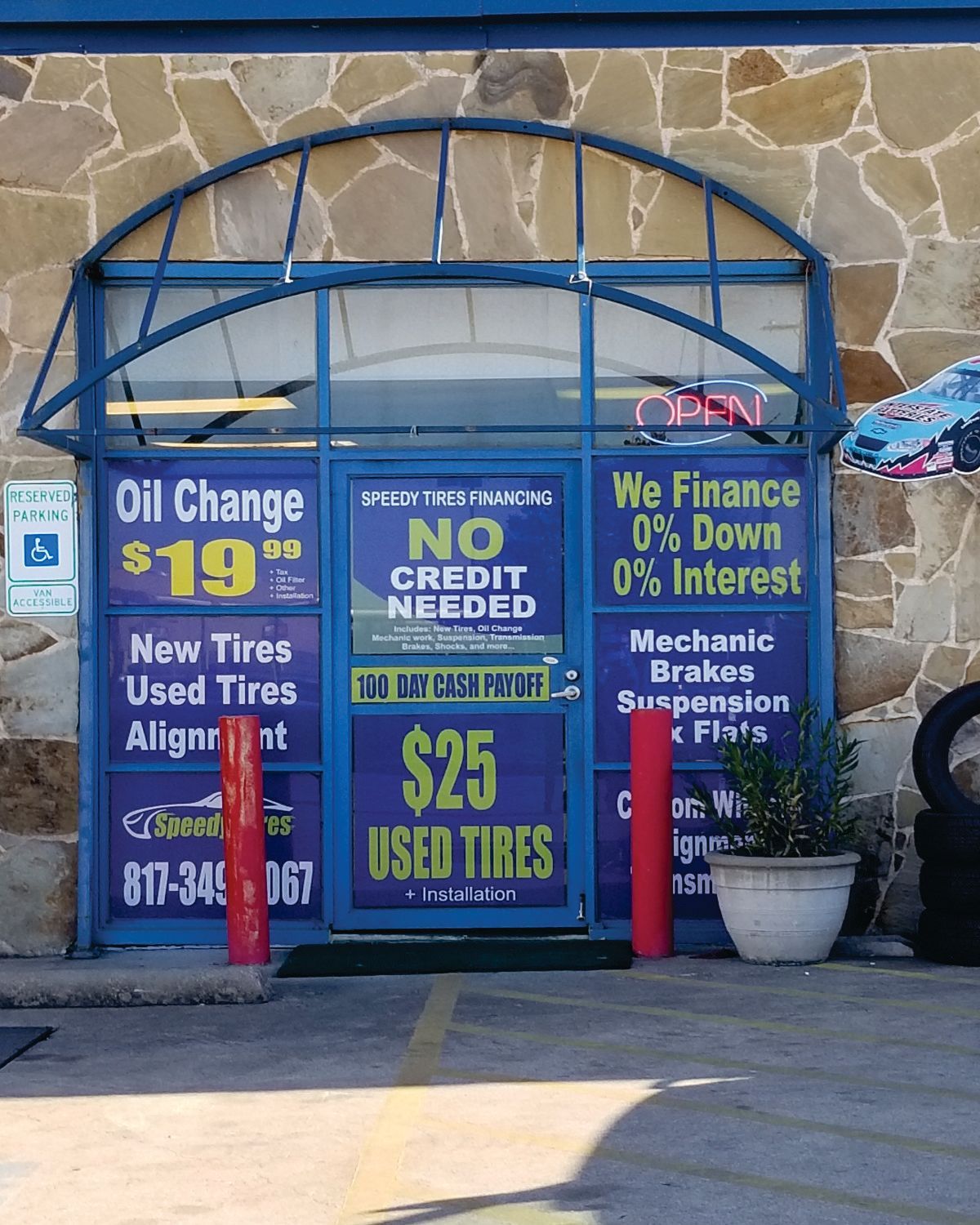 Blue car window with multiple stickers, parked outdoors.