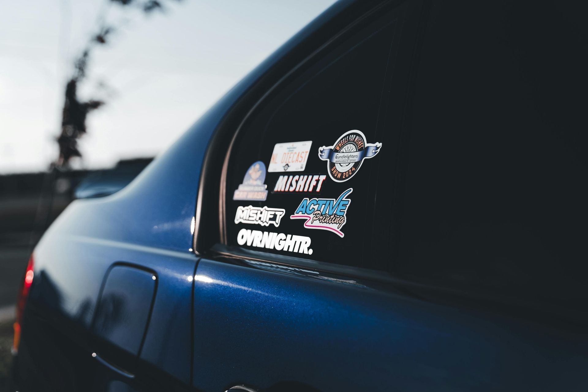 Blue car with stickers on the rear window.