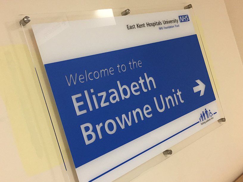 Acrylic sign mounted to wall using stainless steel stand-off fixings