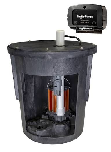 White sump pump in a concrete pit. Black pipe rises above.