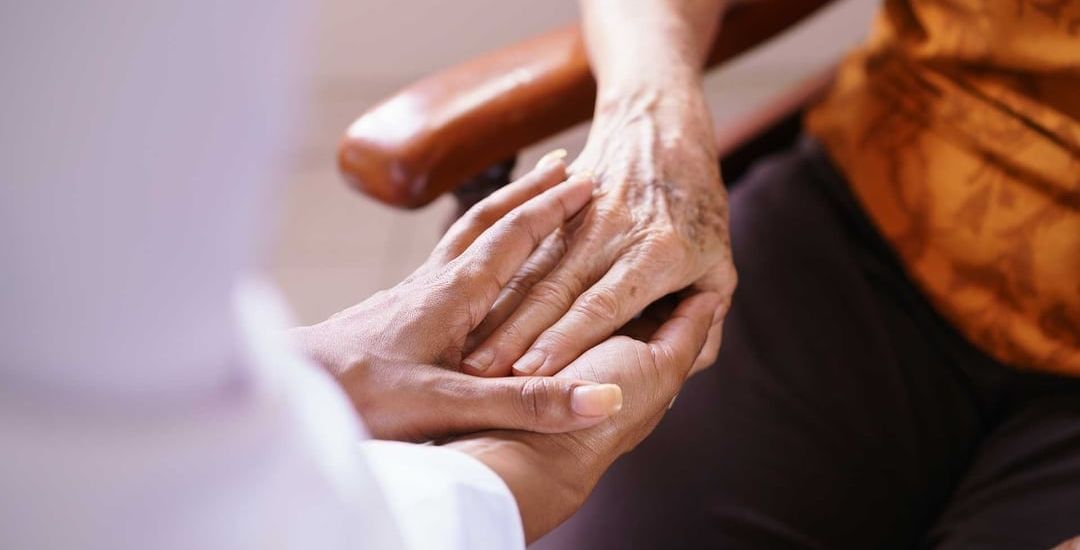 a person holding another person 's hand in a chair