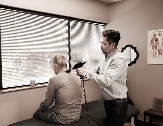 Dr. Alex Oh examining a man's back