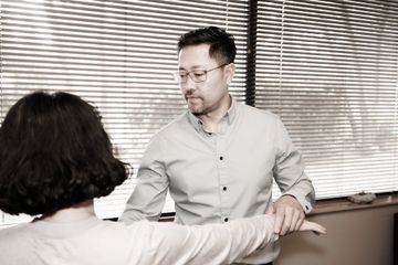 Dr. Alex Oh stretching a woman 's arm