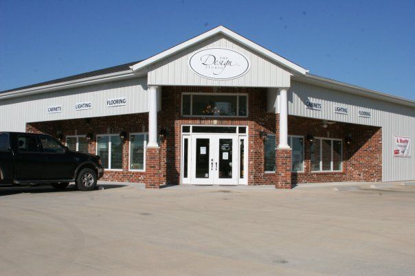 A black truck is parked in front of a large building