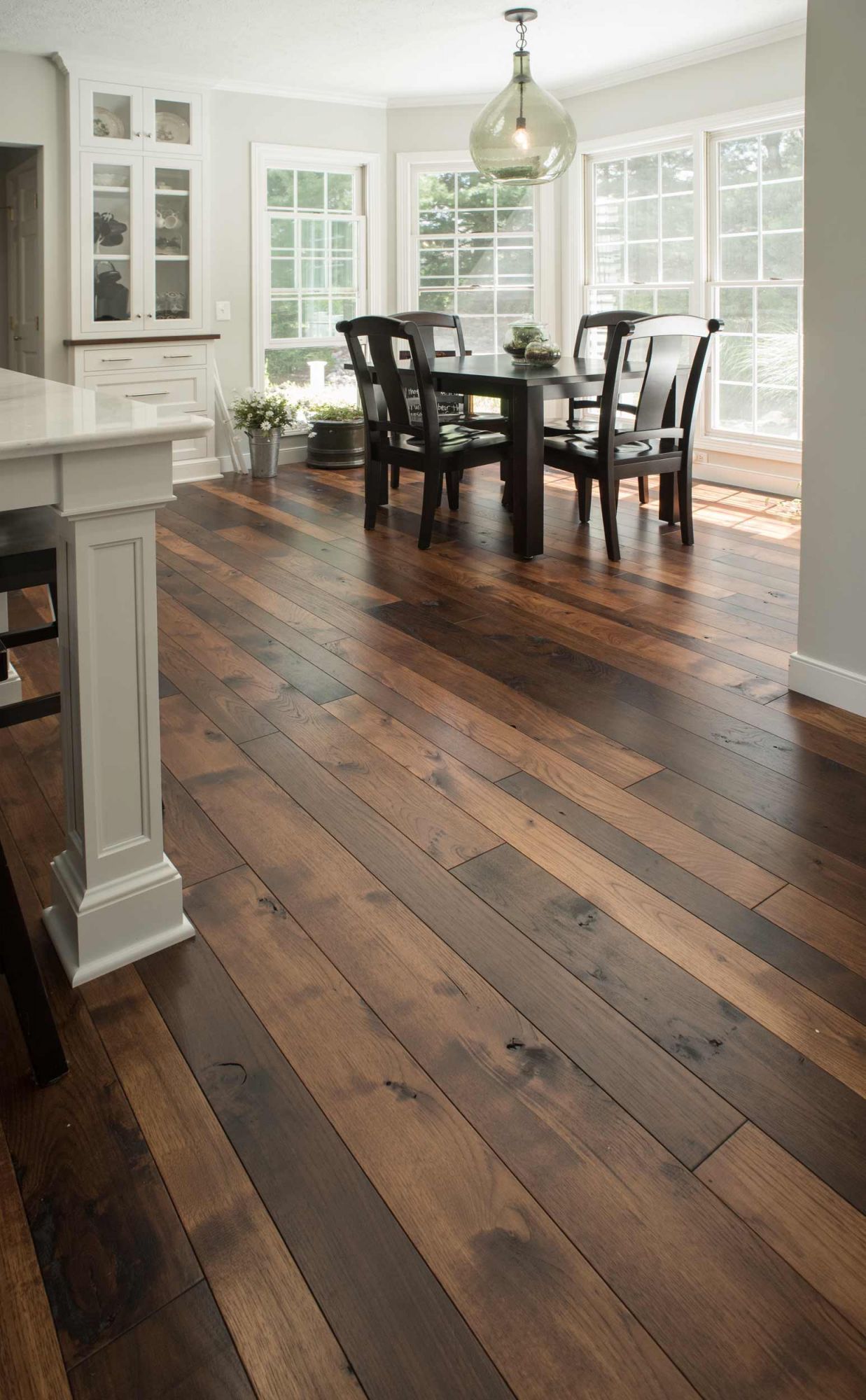 A dining room with hardwood floors and a table and chairs.