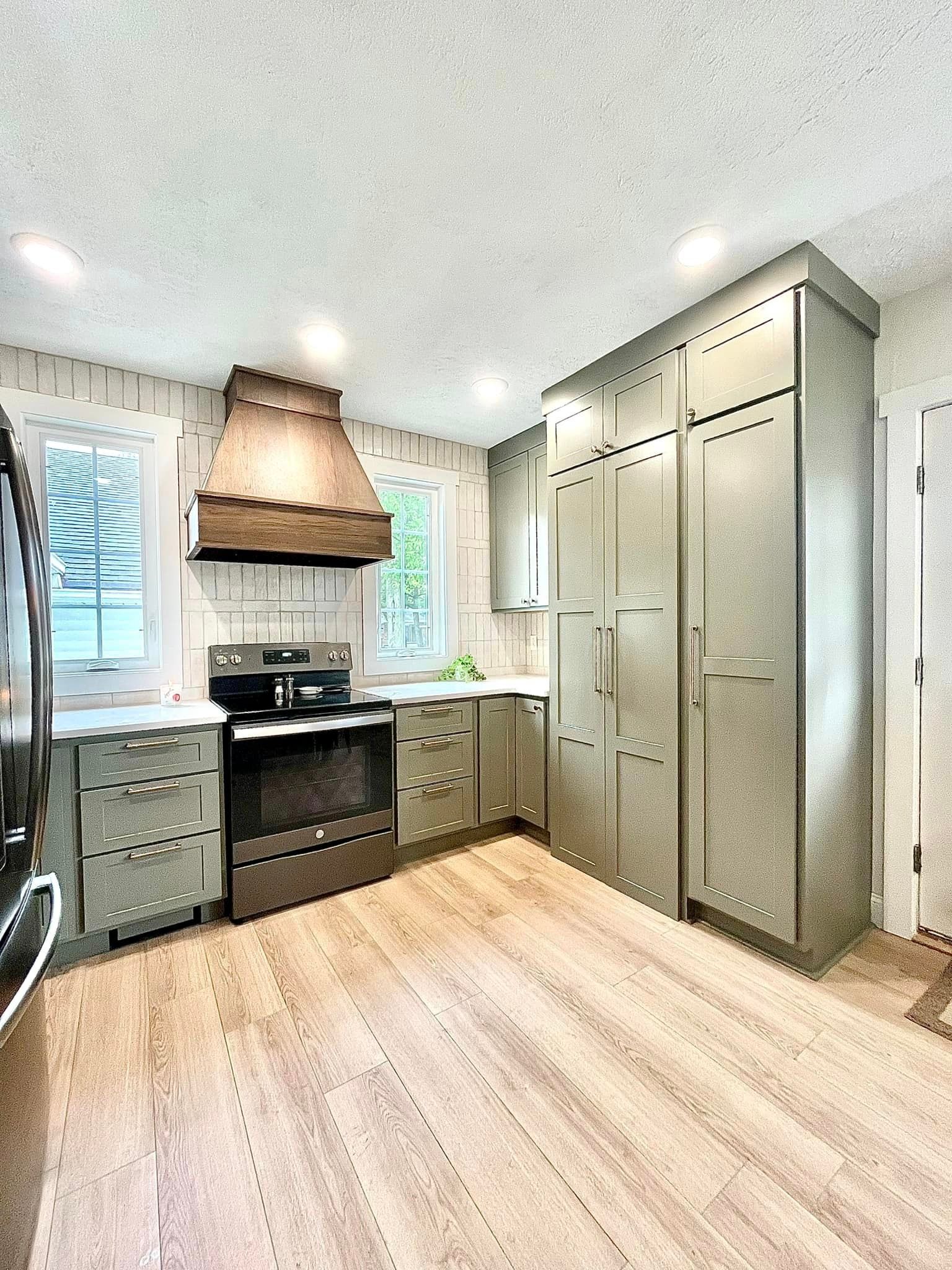 A kitchen with a stove , refrigerator , and cabinets.