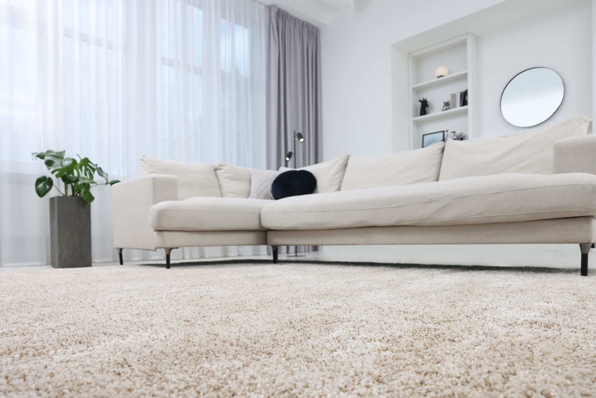 A living room with a white couch and a white carpet